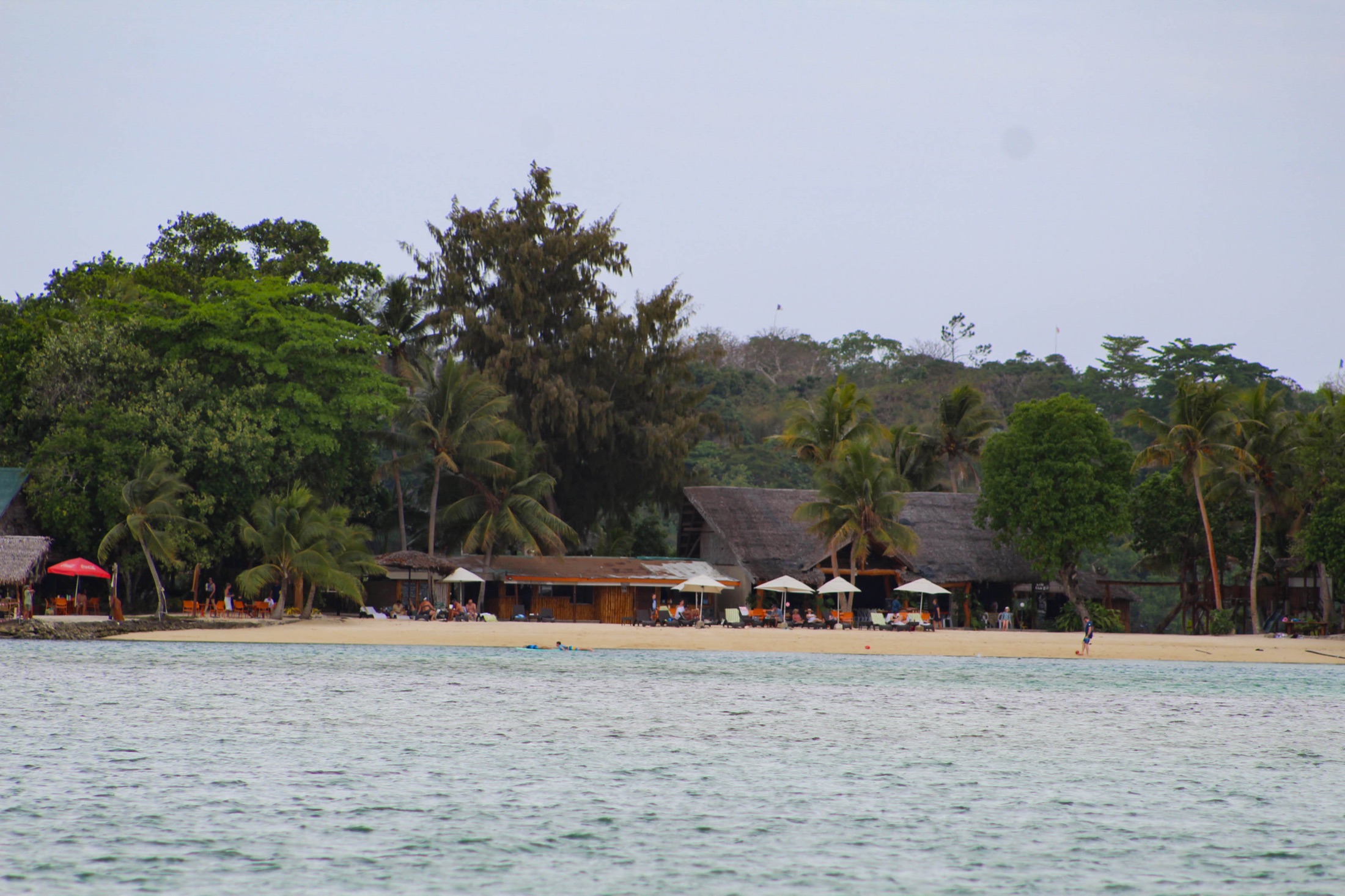 A beachfront resort with palms and a calm island bay.
