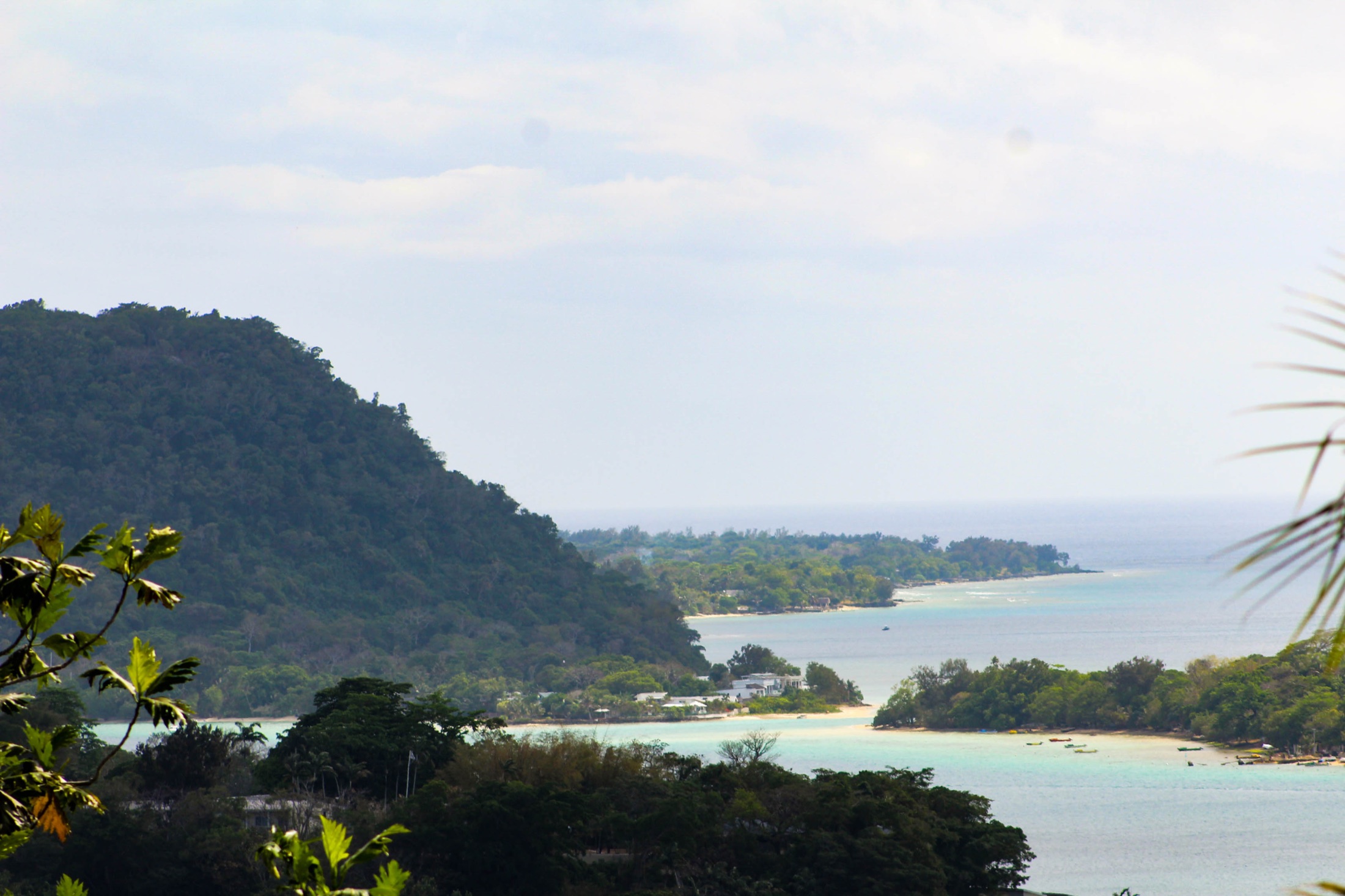 A wide view across a tropical lagoon and green island coastline.